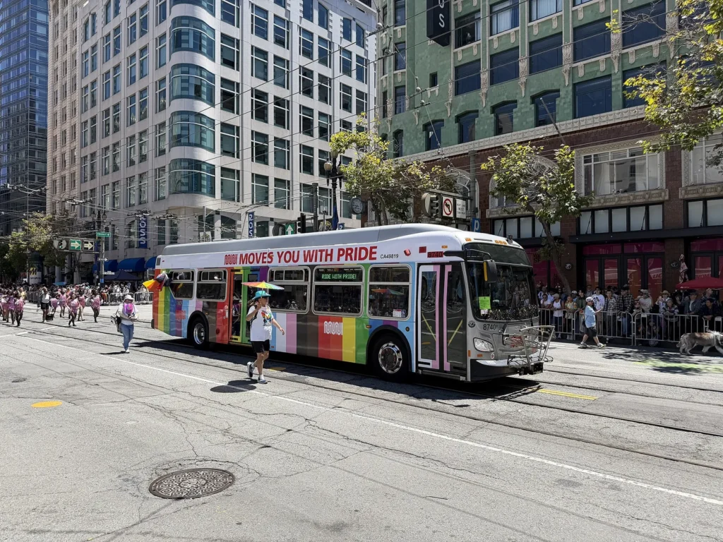 Muni bus decorated for Pride rolling down Market Street during the San Francisco Pride Parade