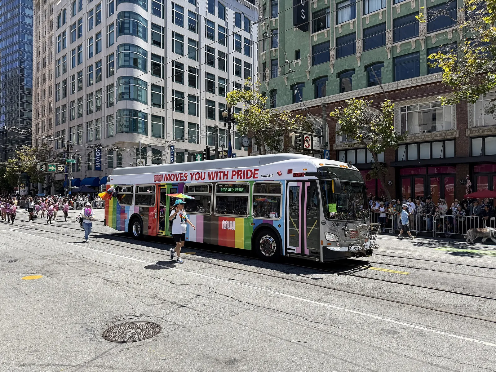 Muni bus decorated for Pride rolling down Market Street during the San Francisco Pride Parade